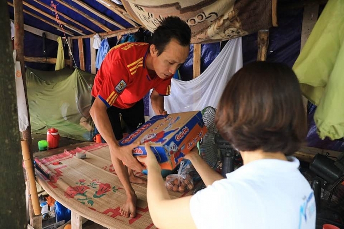 Một nhóm từ thiện trao quà hỗ trợ cho các thợ xây tại khu lán tạm ở Dương Nội, Hà Đông 	 Ảnh: Ngọc Thành