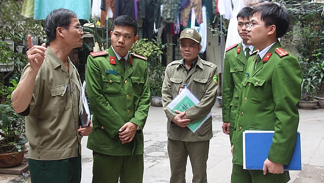 Công an, bảo vệ dân phố phường Tràng Tiền, quận Hoàn Kiếm, Hà Nội, nắm bắt thông tin địa bàn từ người dân. Ảnh: Tiến Thành
