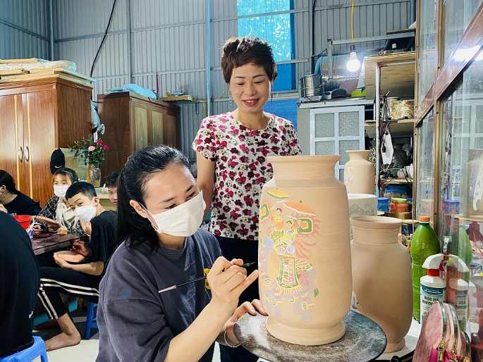 Nghệ nhân Trần Lưu đang dạy cho học viên nắn nót những đường nét tạo nên thương hiệu gốm Bát Tràng