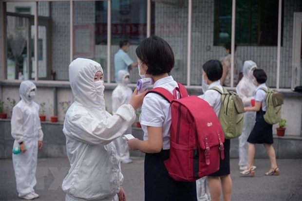 Kiểm tra thân nhiệt nhằm ngăn chặn sự lây nhiễm của dịch COVID-19 tại một trường học ở Bình Nhưỡng, Triều Tiên. (Ảnh: AFP/TTXVN)