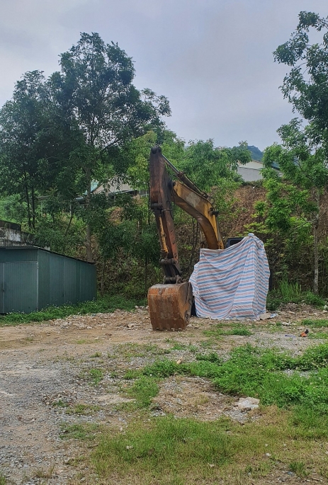 Chiếc máy xúc của Công ty TNHH Quỳnh Phương hiện đang bị tạm giữ tại bãi xe ở thị trấn Sơn Lư