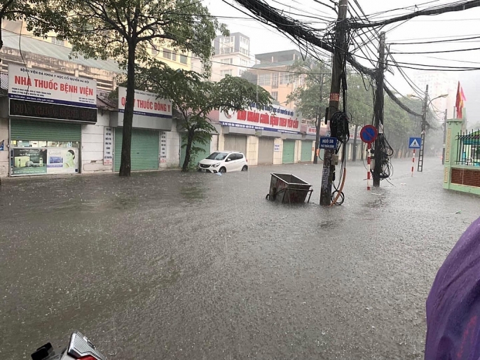 Các xe ô tô buộc phải dừng lưu thông để chờ nước rút bớt. Ảnh chụp phố Trần Bình, Quận Nam Từ Liêm