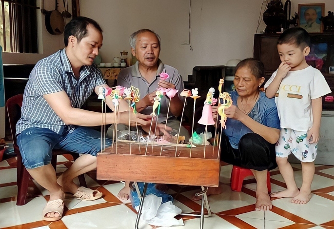 Nghệ nhân Nguyễn Văn Thành (ngoài cùng bên trái) cùng gia đình đang nặn những sản phẩm tò he truyền thống