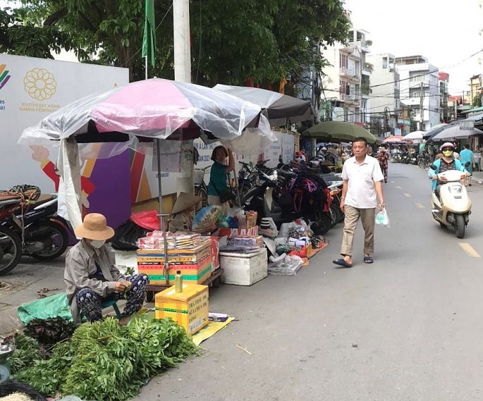 Hàng hoa quả đứng bán ngang nhiên dưới lòng đường phố Nguyễn Hữu Huân.