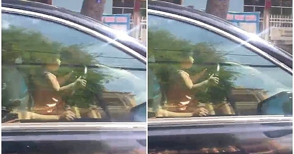 Hình ảnh người đàn ông để bé gái khoảng 4 tuổi ngồi cùng ghế lái, bé gái ôm vô lăng khi xe chạy trên đường. Ảnh: Cắt từ clip