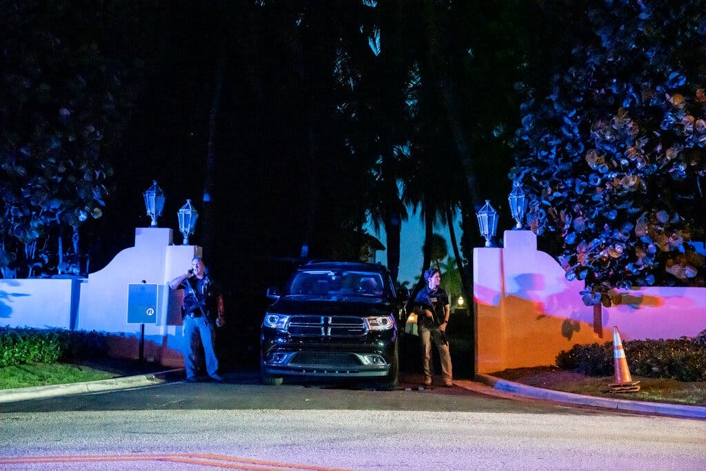 Đặc vụ FBI cầm súng trường đứng bên cạnh ô tô, gác ở lối vào dinh thự Mar-a-Lago. Ảnh: NYT