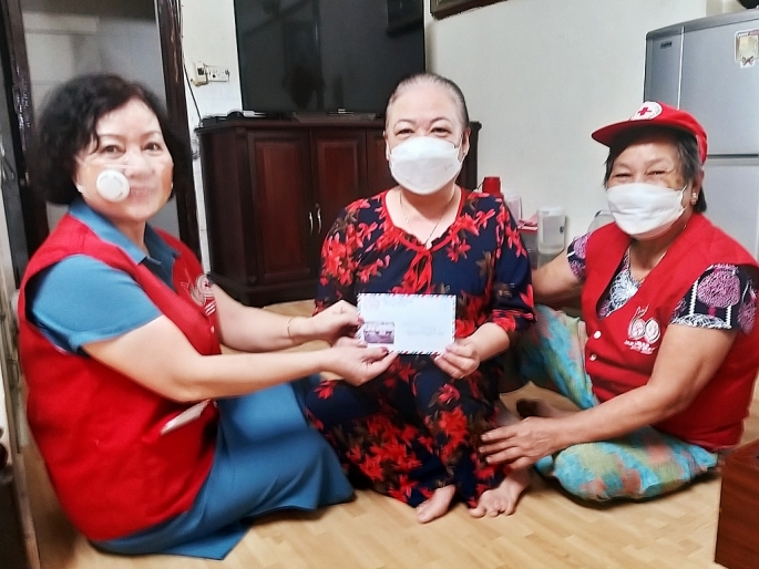 Bà Cao Thị Thu Hà (bên trái) trao quà cho gia đình khó khăn dịch Covid-19. 				ẢNH: M. MIÊN
