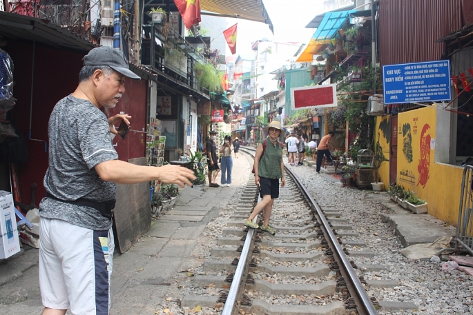 Du khách chụp ảnh trên “phố cà phê đường tàu” ngày 14/9 trước quy định thiết lập rào chắn phong tỏa. Ảnh Mộc Miên