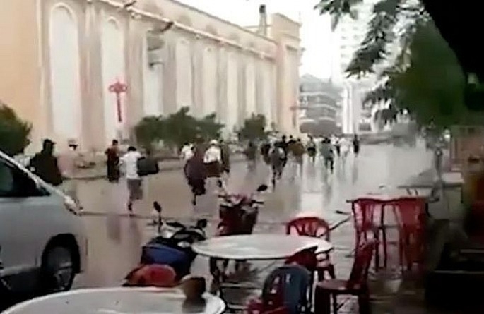 Cảnh tháo chạy trong mưa của hàng chục người, được cho là lao động Việt Nam, ra khỏi một casino ở Campuchia - Ảnh cắt từ clip