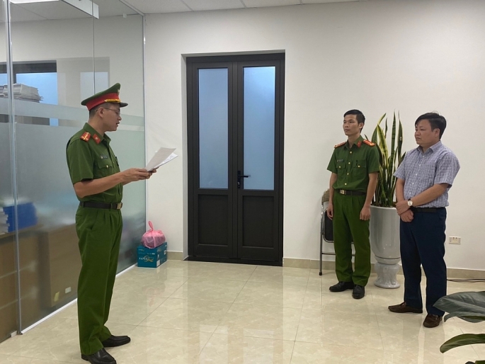 Lực lượng chức năng thực hiện các thủ tục tố tụng đối với bị can Vũ Xuân Lưu (ngoài cùng bên phải)