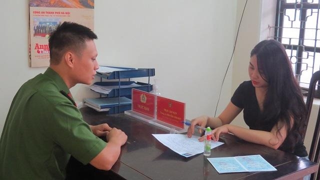 Cán bộ, chiến sỹ Công an thị trấn Xuân Mai hướng dẫn người dân hoàn thiện hồ sơ thủ tục hành chính.