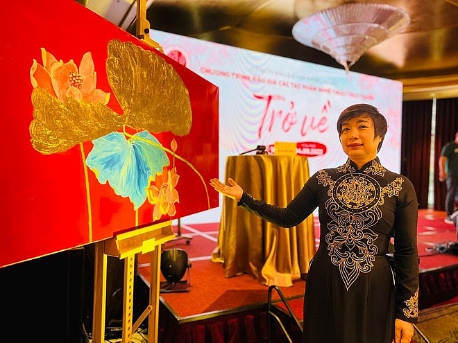 Bà Đỗ Thị Hồng Hạnh chụp ảnh cùng tác phẩm nghệ thuật trong phiên đấu giá