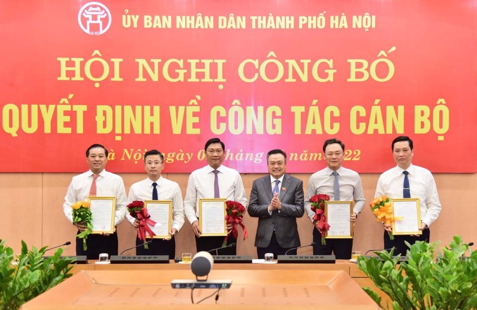 Chủ tịch UBND TP Hà Nội Trần Sỹ Thanh trao quyết định và tặng hoa chúc mừng các đồng chí nhận nhiệm vụ mới.