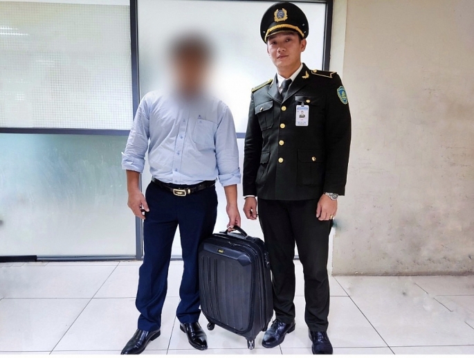 Nhân viên an ninh Cảng HKQT Nội Bài trao trả lại hành lý cho vị khách để quên.