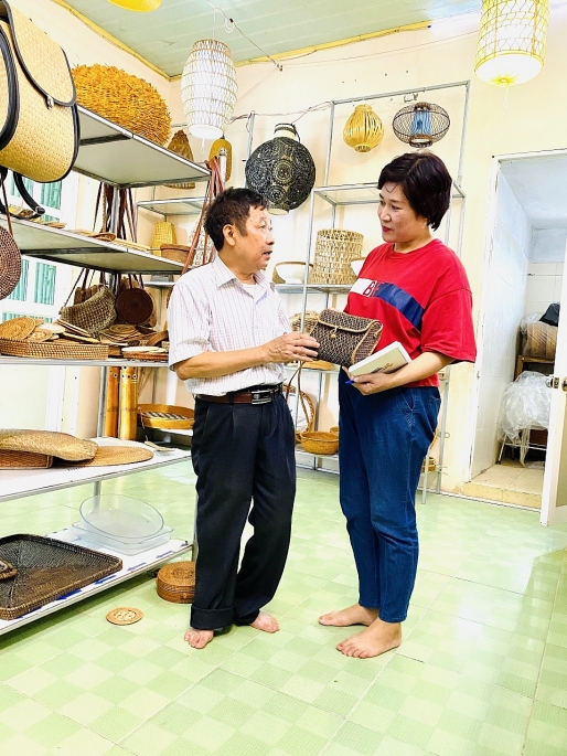 Nghệ nhân Nguyễn Văn Trung đang giới thiệu sản phẩm mây tre đan cho du khách