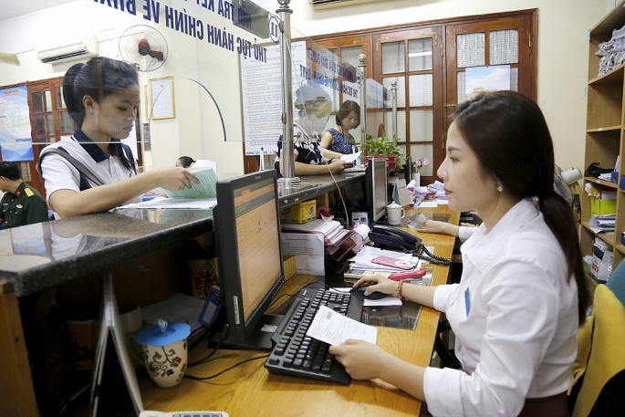 Cán bộ Bảo hiểm xã hội Hà Nội giải quyết thủ tục hành chính cho người dân (Ảnh: Hải Linh)