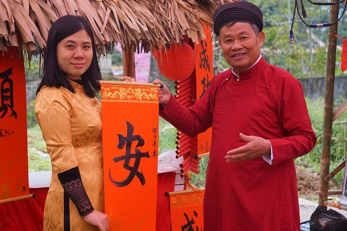 Thầy Đồ tặng chữ cho du khách tại Làng cổ Đông Sơn.