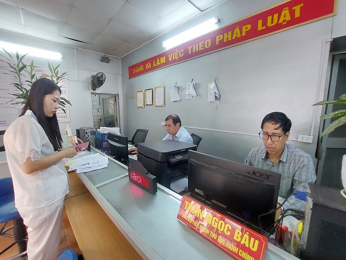 Cán bộ một cửa phường Thịnh Liệt hỗ trợ công dân đến làm thủ tục