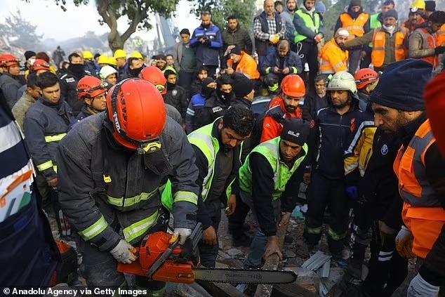 Một nhân viên cứu hộ sử dụng cưa máy để cắt qua các mảnh vỡ và tiếp cận một gia đình vẫn còn sống sau 108 giờ dưới lòng đất
