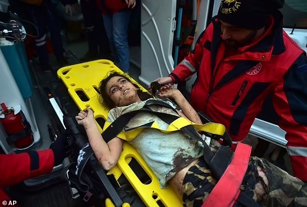 Một nhân viên cứu hộ chăm sóc một bé gái được giải cứu 4 ngày sau trận động đất, ở Kahramanmaras, miền nam Thổ Nhĩ Kỳ
