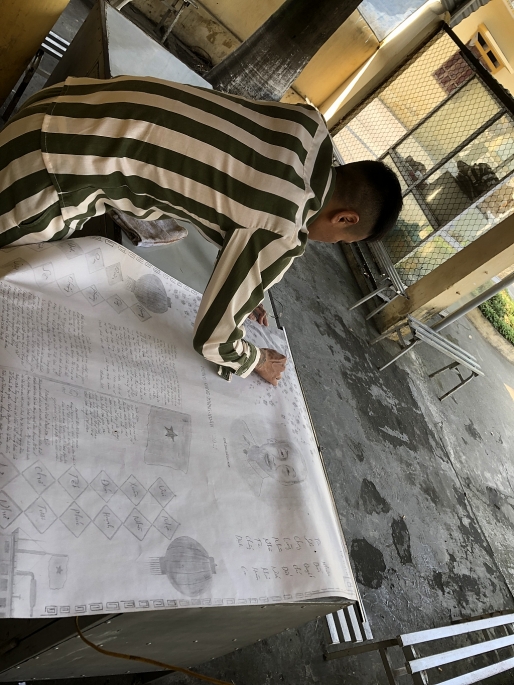Nguyễn Văn Hiệp đang chăm chú chỉnh sửa bức tranh cho tờ báo tường của đội