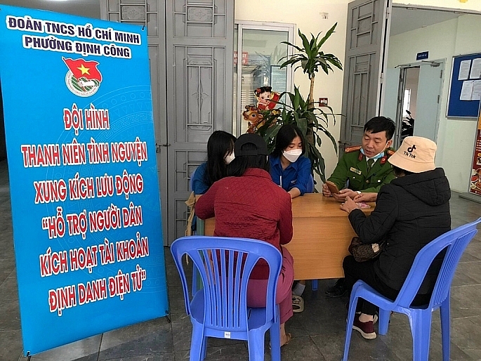 Cán bộ, chiến sĩ Công an phường Định Công, quận Hoàng Mai đã trực tiếp hướng dẫn từng người dân làm quen với các bước thực hiện dịch vụ công trên nền tảng điện tử.(ảnh: Văn Biên)