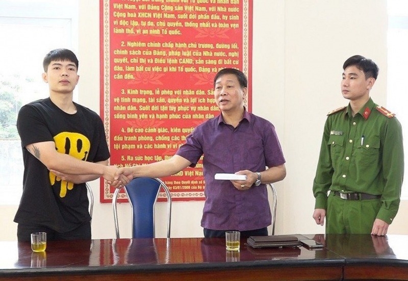 Anh Nguyễn Văn Sơn (ngoài cùng bên trái) bàn giao tiền nhặt được cho ông Phạm Văn Trí (giữa) tại Cơ quan Công an.