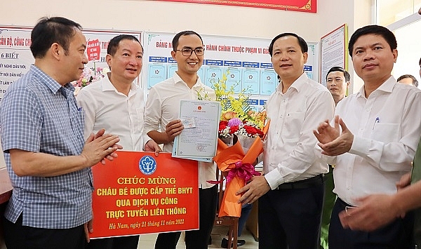 -	Đại diện BHXH Việt Nam trao thẻ BHYT đầu tiên trên toàn quốc cho gia đình bé gái dưới 6 tuổi được thực hiện qua Dịch vụ công liên thông (ảnh tư liệu)
