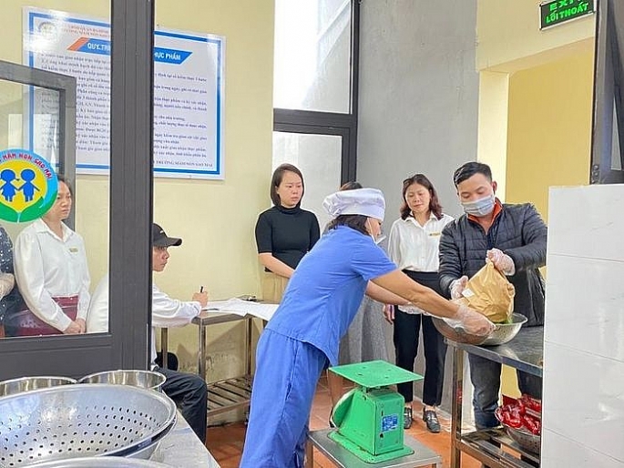 Phụ huynh giám sát giao nhận thực phẩm tại Trường Mầm non Sao Mai (quận Ba Đình). Ảnh: Song Lam