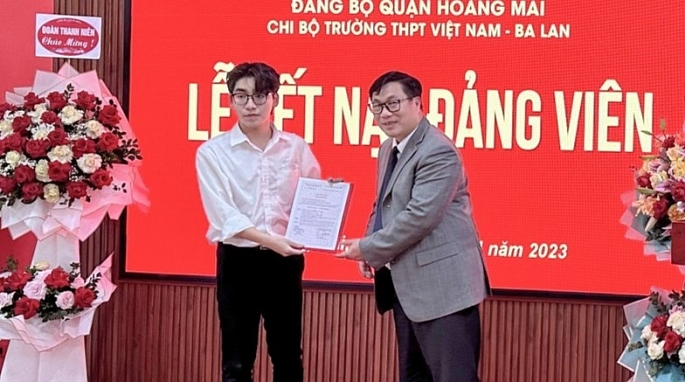 Đồng chí Nguyễn Quang Hiếu - Bí thư Quận ủy Hoàng Mai trao Quyết định kết nạp Đảng cho em Nguyễn Minh Hiển
