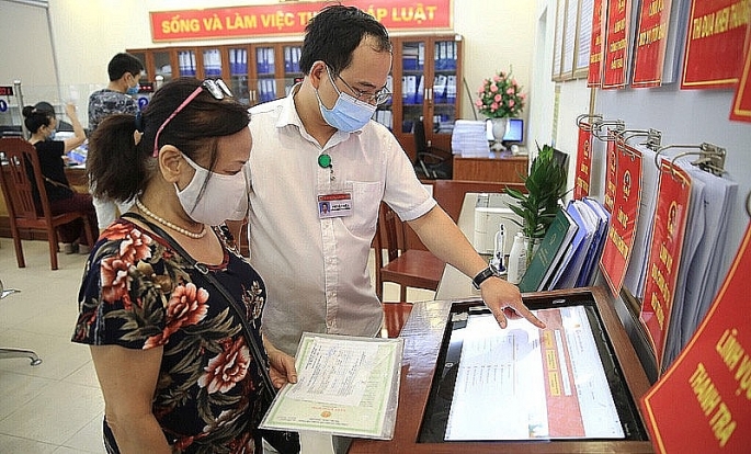 -	Cán bộ hướng dẫn người dân sử dụng DVCTT tại bộ phận một cửa cấp phường ở quận Thanh Xuân, Hà Nội. Ảnh tư liệu