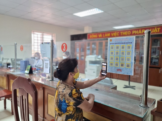 Người dân tại Hà Nội tra cứu thông tin thủ tục hành hính bằng mã QR Code tại bộ phận một cửa của UBND phường