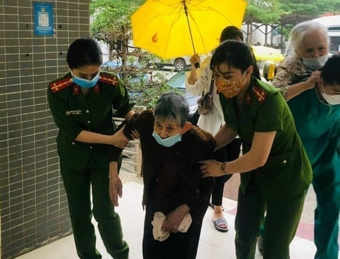 Cán bộ, chiến sĩ công an quận Hà Đông giúp đỡ người dân đến làm thủ tục cấp CCCD. Ảnh: N. Trang