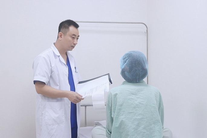 Bác sĩ Nguyễn Đình Minh thăm khám cho bệnh nhân nâng ngực bằng sóng xung kích