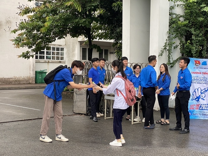 Lực lượng tình nguyện viên phát nước cho thí sinh tại điểm thi trường THPT Phúc Lợi (ảnh Hồng Giang)