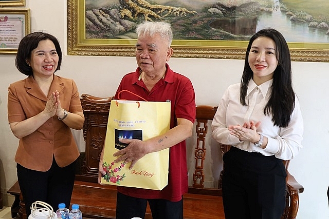 Bí thư Quận ủy Tây Hồ Lê Thị Thu Hằng (bên trái) và Phó Chủ tịch UBND quận Tây Hồ Bùi Lan Phương (bên phải) tặng quà cho thương binh hạng 2/4 Trần Văn Chiến. Ảnh: Ban Tuyên giáo quận Tây Hồ.