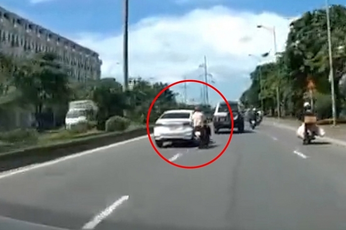 Hình ảnh người đàn ông đi xe máy bị ô tô tạt đầu, ngã ra đường.