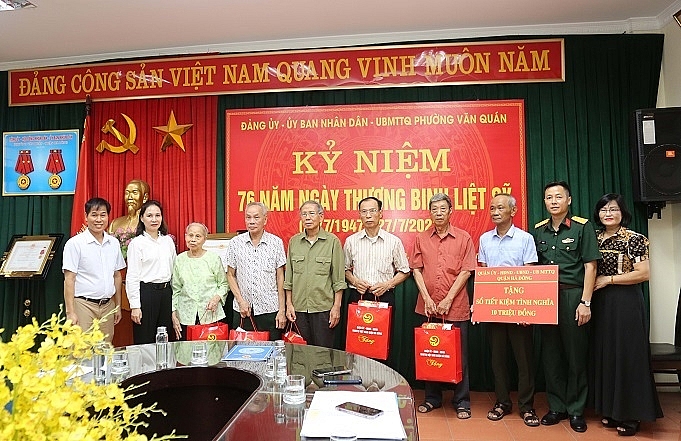 Chủ tịch UBND quận Hà Đông Cấn Thị Việt Hà (thứ 2 từ trái sang) thăm, tặng quà và sổ tiết kiệm cho người có công tiêu biểu phường Văn Quán. Ảnh: Nam Duy