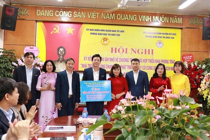 Đại diện ngành giáo dục quận Nam Từ Liêm tặng quà đỡ đầu các em học sinh có hoàn cảnh khó khăn huyện Mỹ Đức với số tiền 240 triệu đồng Ảnh: Ngọc Minh