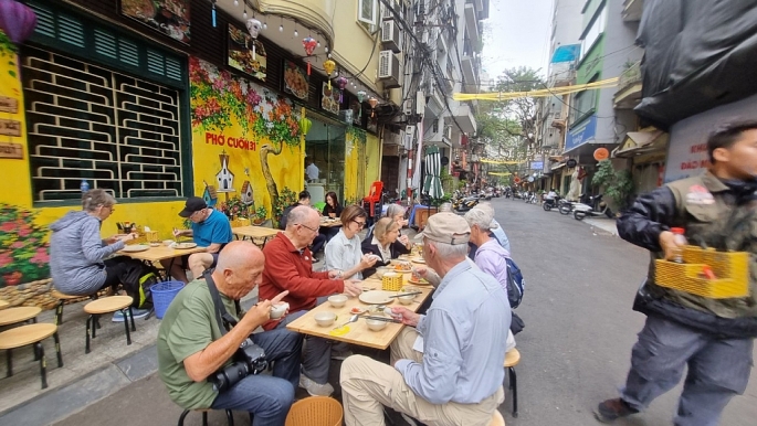 Du khách nước ngoài chụp ảnh kỷ niệm với khu ẩm thực kết hợp phố đi bộ Đảo Ngọc - Ngũ Xá          Ảnh Mộc Miên