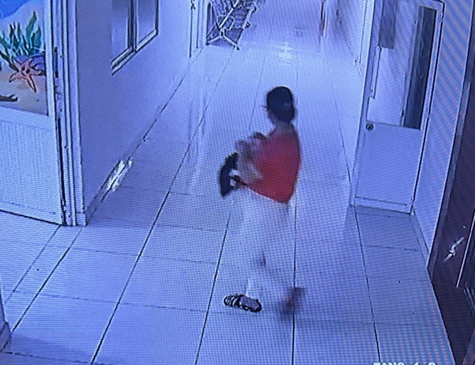 Người phụ nữ luống tuổi bế cháu bé rời khỏi bệnh viện (ảnh do camera an ninh ghi lại)