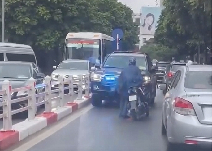 Hình ảnh chiếc xe máy chặn đầu xe biển xanh đang phát tín hiệu ưu tiên trên phố Chu Văn An, quận Ba Đình, Hà Nội.	 Ảnh chụp màn hình