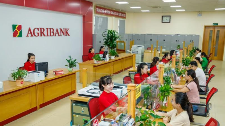 Khách hàng giao dịch tại Agribank 	Ảnh: Vietnam+