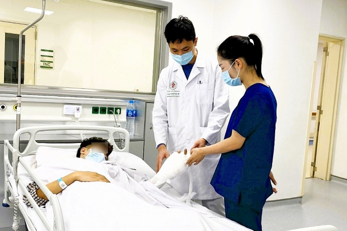 Bác sĩ Bệnh viện Trung ương Quân đội 108 kiểm tra tình trạng vết thương cho bệnh nhân gặp tai nạn do pháo nổ. Ảnh: BVCC