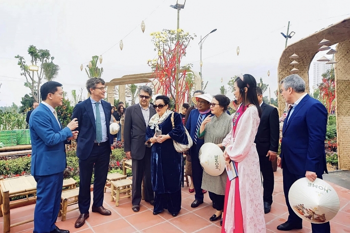 Các du khách nước ngoài hào hứng trải nghiệm tại Đường hoa Home Hanoi Xuan 2024. Ảnh:T.T