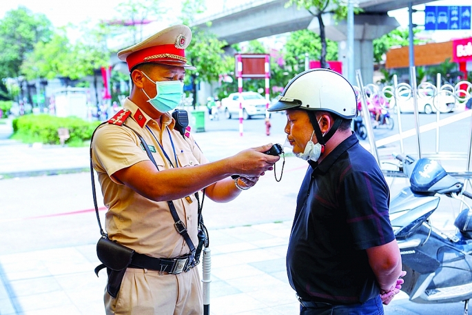 Cảnh sát giao thông Hà Nội đo nồng độ cồn đối với người tham gia giao thông.	Ảnh: Bạch Dương