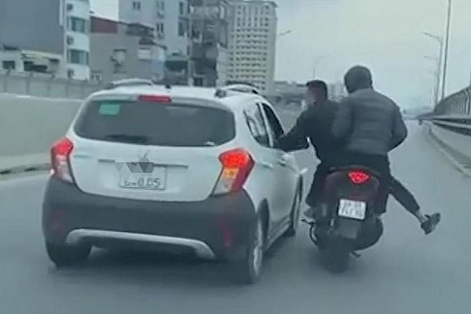 Hình ảnh hai thanh niên đầu trần, đi xe máy và gây sự với người đi ô tô trên đường vành đai 2. 	Ảnh cắt từ video