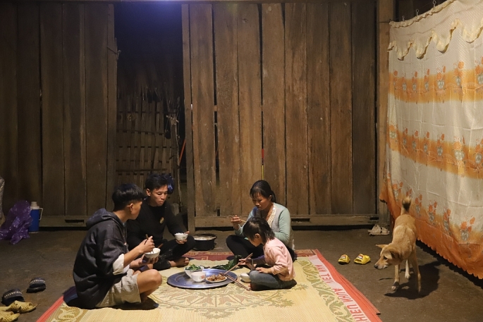 Gia đình anh Triệu Quý Tiến ăn cơm dưới ánh đèn sáng rực   Ảnh: Khánh Huy