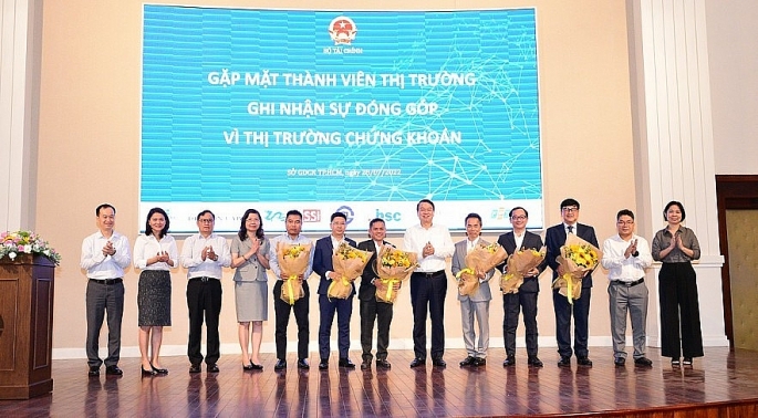 Thứ trưởng Nguyễn Đức Chi (thứ 6 từ trái sang) tặng hoa cảm ơn các thành viên thị trường ngày 28_7_2022