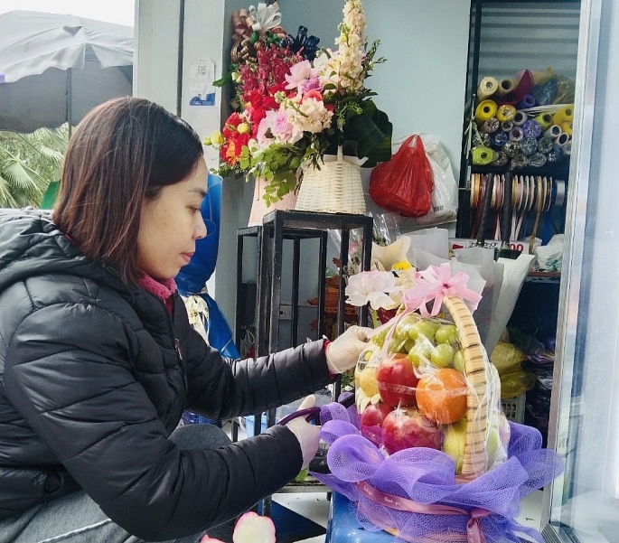 Gần đây, các loại hình giỏ hoa quả, hoa sáp, các chậu hoa lan được khá nhiều người lựa chọn làm quà tặng (Ảnh chụp tại 1 cửa hàng hoa quả nhập khẩu ở Linh Đàm, quận Hoàng Mai, Hà Nội). 	Ảnh: Nguyễn Vũ